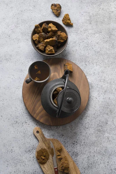 Organic Chaga tea in cup. Trendy Russian healthy infusion from birch mushroom on light background. View from above. Horizontal