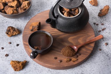 Chaga mantarı doğrama ve çaydanlıkta sağlıklı içecek yapma hazırlığı. Modaya uygun sağlıklı huş mantarları. Kapat..