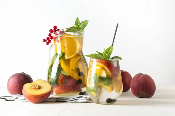 自制柠檬水与桃和浆果装饰薄荷白色背景 夏天健康的饮料 靠近点 — 图库照片