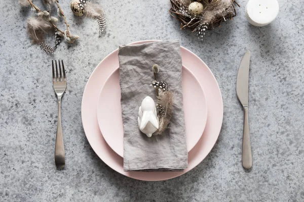 ピンクプレート ウサギと灰色のテーブルの上にウズラの卵とイースターテーブルの設定 エレガンスディナー 最上階だ 水平構成 スペースのコピー — ストック写真