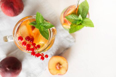 Beyaz arka planda şeftalili, şeftalili, naneli taze içecek. Sağlıklı yaz içkisi. Yukarıdan bak. Kapat..