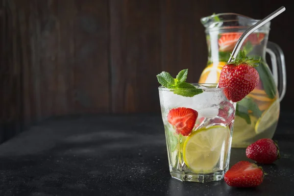 用石灰 草莓在玻璃杯中脱毒柠檬水 并在深色板上隔离 夏天健康的饮料 横向观点 — 图库照片