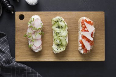 Taze sebzeli, turplu, domatesli, salatalıklı ve mikroyeşillikli üç farklı tost. Yukarıdan görüntüle.