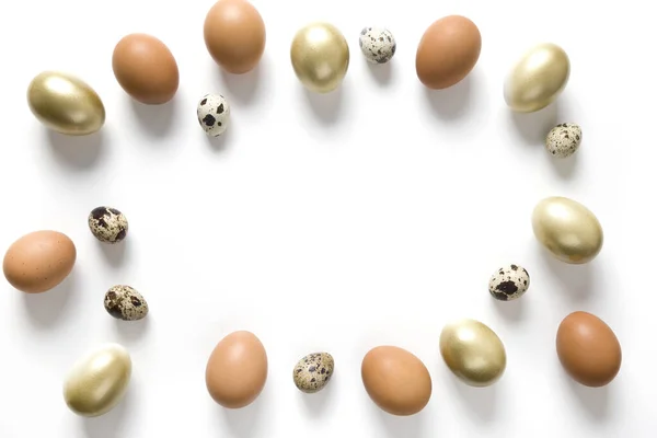 Easter frame of golden, quail, chicken eggs on white. View from above. Space for text. — Stockfoto