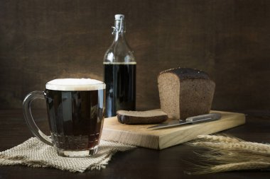 Russian beverage fermented kvass from rye bread in half-liter mug on dark. Close up.