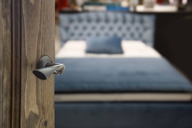 Open wooden door and view to bedroom. Blurred background. Abstract pattern.