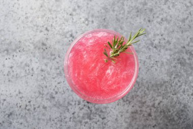 Bir bardak köpüklü gül şarabı ve gri masada yenebilir pırıl pırıl pırıl biberiye. Yukarıdan bak. Kapat..