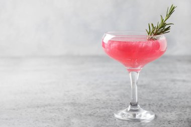 Bir bardak köpüklü gül şarabı ve gri masada yenebilir pırıl pırıl pırıl biberiye. Kapat..