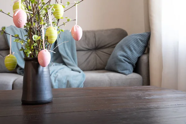 Spring home interior with Easter tree decorated colorful eggs. Quarantine. Self isolation.