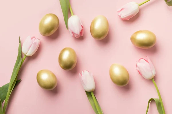 Пасхальные Золотые Яйца Розовые Тюльпаны Фоне Розовой Бумаги Вид Сверху — стоковое фото