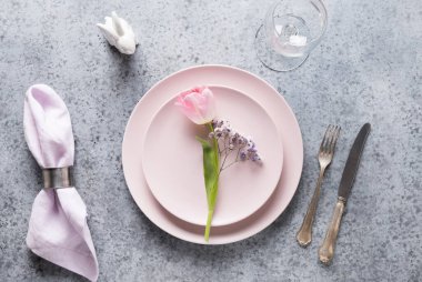 Paskalya sofrası. Gri taş masada taze pembe lale var. Üst Manzara. Zarif bir akşam yemeği..