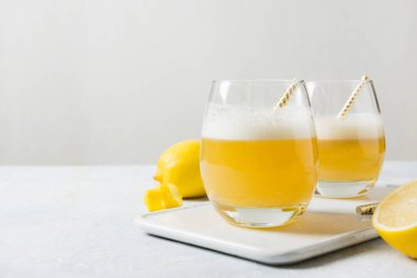 İki viski kokteyli, malzemeli, limon suyu, beyaz masada cam içinde yumurta beyazı. Boşluğu kopyala.