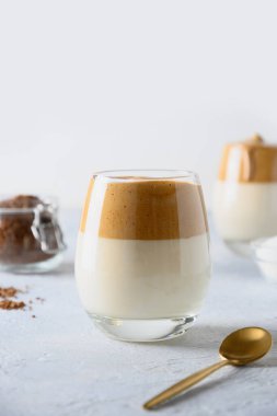 Beyaz arka planda iki bardak Kore Dalgona kahvesi. Dikey çekim. Kapat..