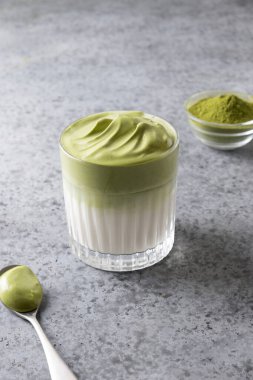 Dalgona buzlu Matcha latte ve kremalı kibrit. Zamanda kendini izole eden enfes viral içecekler. Dikey biçim.
