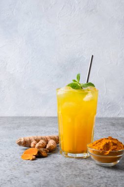 Altın sütlü zerdeçal, taze buzlu latte, naneli latte filizi. Ayurvedik içecekler arka planda. Dikey biçim.