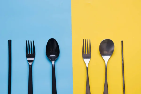 Comparison of reusable metal silverware and plastic cutlery. View from above. Flat lay. Zero waste, save planet. Danger of plastic, but virus safe.