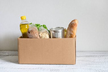 Eve yemek teslimatı. Koronavirüs zamanında güvenli teslimat. Bağış yemeği. Yağmurlu günler için stoklarla dolu bir kutu. Boşluğu kopyala.