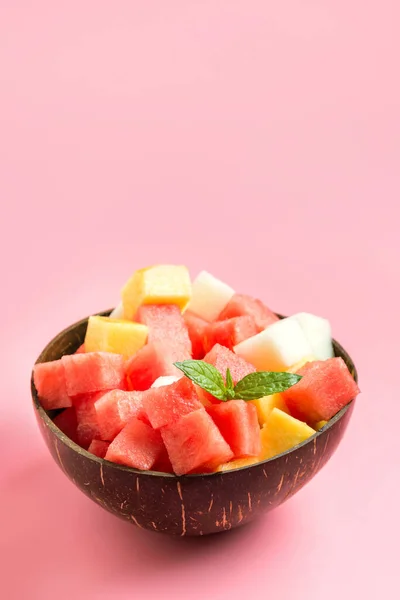 夏季热带色拉西瓜 甜瓜和芒果在椰子碗粉红色背景 垂直格式 文字空间 干净的食物素食靠近点 — 图库照片
