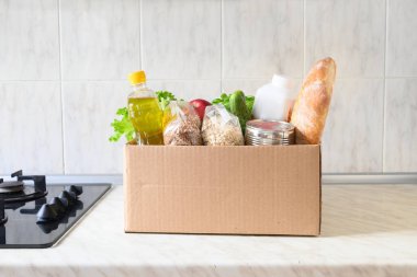 Eve yemek teslimatı. Koronavirüs zamanında güvenli teslimat. Bağış yemeği. Yağmurlu günler için stoklarla dolu bir kutu.