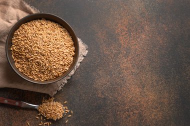 Kahverengi arka planda tahtadan yapılmış tahıllı farro. Üst Manzara. Metin için boşluk.