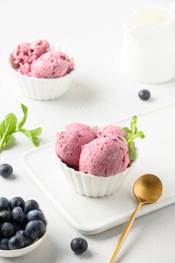 Beyaz arka planda yaban mersinli dondurma. Kapatın. Dikey.