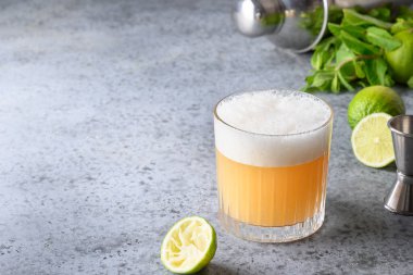 Pisco kokteyli. Limonlu viski. Yumurta beyazı. Gri taş masadaki şekerli şurup. Metin için boşluk.