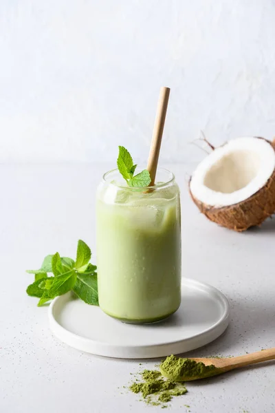 将绿茶放在玻璃杯中 用椰子牛奶装饰薄荷糖 白色底色 垂直格式 — 图库照片