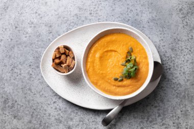 Balkabağı ve havuç çorbası kremalı garnitür mikroyeşili ve gri arka plan. Yukarıdan görüntüle.