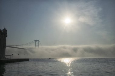 İstanbul 'un sisli sabahında Boğaz Köprüsü ve Sürat Teknesi