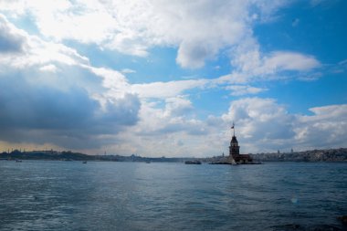 İstanbul Boğazı 'nda yüzen turist tekneli Maiden Tower veya Kiz Kulesi. İstanbul 'un tarihi işareti Bakire Kulesi