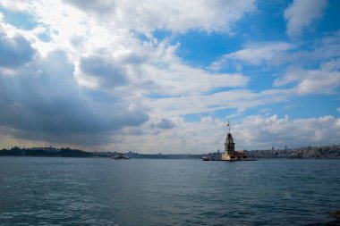 İstanbul Boğazı 'nda yüzen turist tekneli Maiden Tower veya Kiz Kulesi. İstanbul 'un tarihi işareti Bakire Kulesi