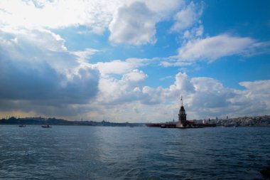 İstanbul Boğazı 'nda yüzen turist tekneli Maiden Tower veya Kiz Kulesi. İstanbul 'un tarihi işareti Bakire Kulesi