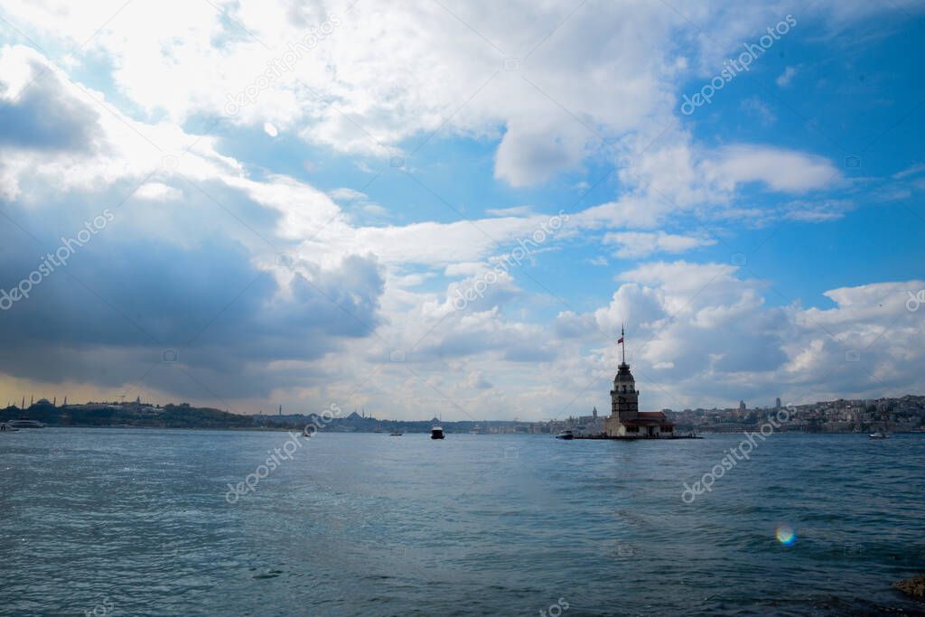 Maiden Tower or Kiz Kulesi with floating tourist boats on Bosphorus in Istanbul.  Maiden Tower is the historical sign of Istanbul
