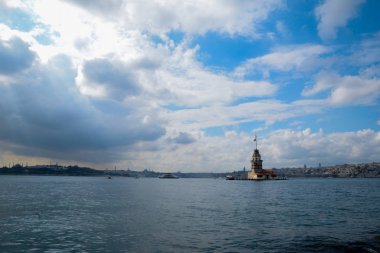 İstanbul Boğazı 'nda yüzen turist tekneli Maiden Tower veya Kiz Kulesi. İstanbul 'un tarihi işareti Bakire Kulesi
