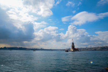 İstanbul Boğazı 'nda yüzen turist tekneli Maiden Tower veya Kiz Kulesi. İstanbul 'un tarihi işareti Bakire Kulesi