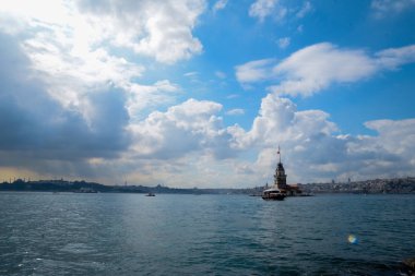 İstanbul Boğazı 'nda yüzen turist tekneli Maiden Tower veya Kiz Kulesi. İstanbul 'un tarihi işareti Bakire Kulesi