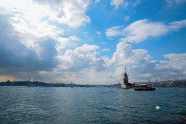 İstanbul Boğazı 'nda yüzen turist tekneli Maiden Tower veya Kiz Kulesi. İstanbul 'un tarihi işareti Bakire Kulesi