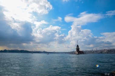 İstanbul Boğazı 'nda yüzen turist tekneli Maiden Tower veya Kiz Kulesi. İstanbul 'un tarihi işareti Bakire Kulesi