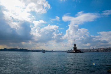 İstanbul Boğazı 'nda yüzen turist tekneli Maiden Tower veya Kiz Kulesi. İstanbul 'un tarihi işareti Bakire Kulesi