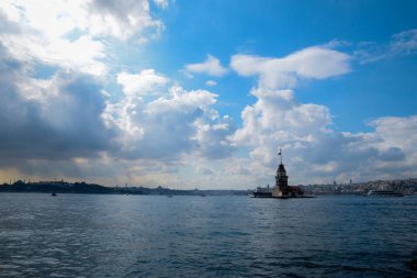 İstanbul Boğazı 'nda yüzen turist tekneli Maiden Tower veya Kiz Kulesi. İstanbul 'un tarihi işareti Bakire Kulesi