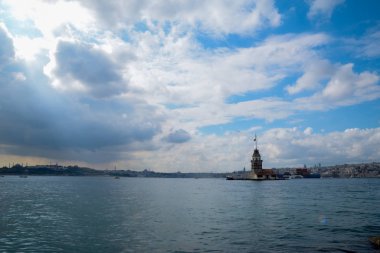 İstanbul Boğazı 'nda yüzen turist tekneli Maiden Tower veya Kiz Kulesi. İstanbul 'un tarihi işareti Bakire Kulesi