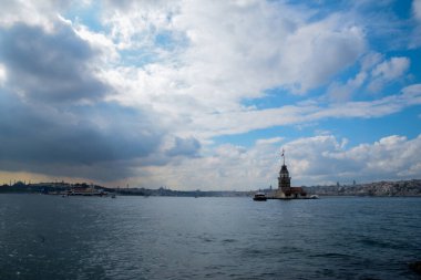 İstanbul Boğazı 'nda yüzen turist tekneli Maiden Tower veya Kiz Kulesi. İstanbul 'un tarihi işareti Bakire Kulesi