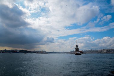 İstanbul Boğazı 'nda yüzen turist tekneli Maiden Tower veya Kiz Kulesi. İstanbul 'un tarihi işareti Bakire Kulesi