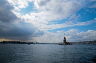 İstanbul Boğazı 'nda yüzen turist tekneli Maiden Tower veya Kiz Kulesi. İstanbul 'un tarihi işareti Bakire Kulesi