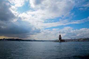 İstanbul Boğazı 'nda yüzen turist tekneli Maiden Tower veya Kiz Kulesi. İstanbul 'un tarihi işareti Bakire Kulesi