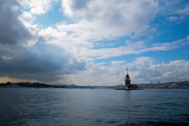 İstanbul Boğazı 'nda yüzen turist tekneli Maiden Tower veya Kiz Kulesi. İstanbul 'un tarihi işareti Bakire Kulesi