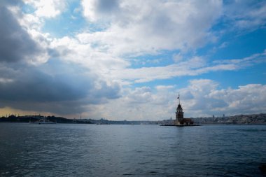İstanbul Boğazı 'nda yüzen turist tekneli Maiden Tower veya Kiz Kulesi. İstanbul 'un tarihi işareti Bakire Kulesi