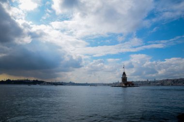 İstanbul Boğazı 'nda yüzen turist tekneli Maiden Tower veya Kiz Kulesi. İstanbul 'un tarihi işareti Bakire Kulesi