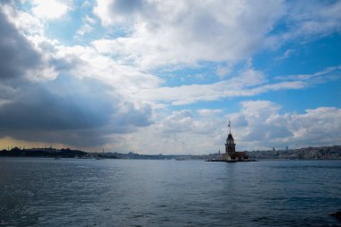 İstanbul Boğazı 'nda yüzen turist tekneli Maiden Tower veya Kiz Kulesi. İstanbul 'un tarihi işareti Bakire Kulesi