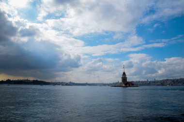 İstanbul Boğazı 'nda yüzen turist tekneli Maiden Tower veya Kiz Kulesi. İstanbul 'un tarihi işareti Bakire Kulesi